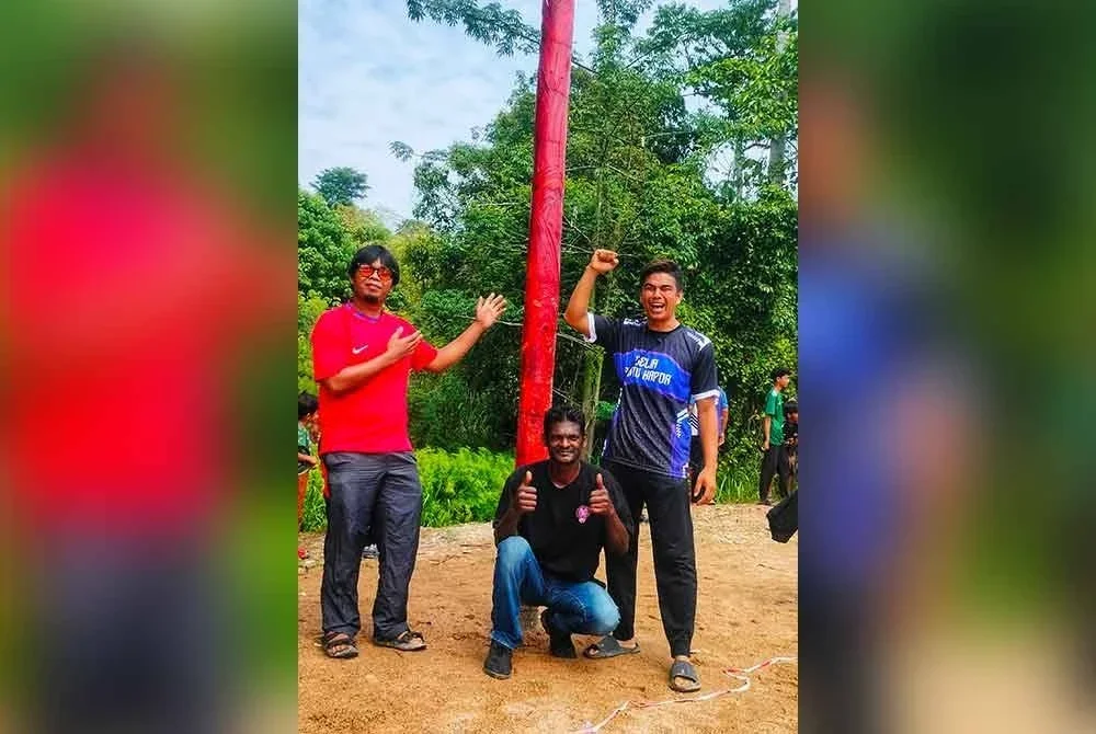 Dari kiri: Muhammad Fatah, Doraisamy dan Suhaimi antara peserta yang mengambil bahagian dalam acara panjat batang pinang licin.