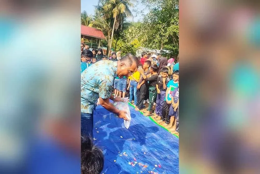 Ridzuan menabur gula-gula untuk acara kategori kanak-kanak.