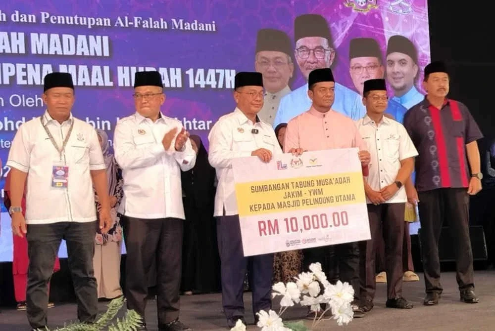 Mohd Na'im menyampaikan sumbangan Musa'adah kepada salah satu penerima institusi agama pada Majlis Penyampaian Sumbangan Musa’adah Al-Falah Madani di Masjid Jamek Beserah pada Ahad.