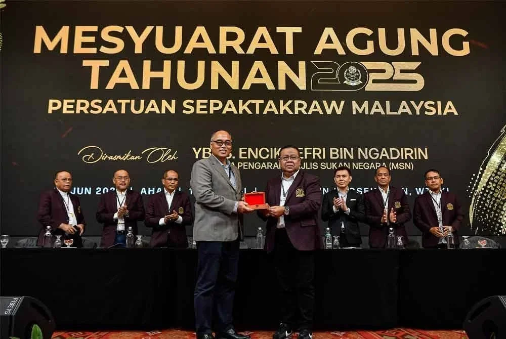 Jefri (depan,kiri) menerima cenderahati dari Mohd Sumali selepas merasmikan mesyuarat agung tahuan PSM di Kuala Lumpur pada Ahad. Foto Bernama.