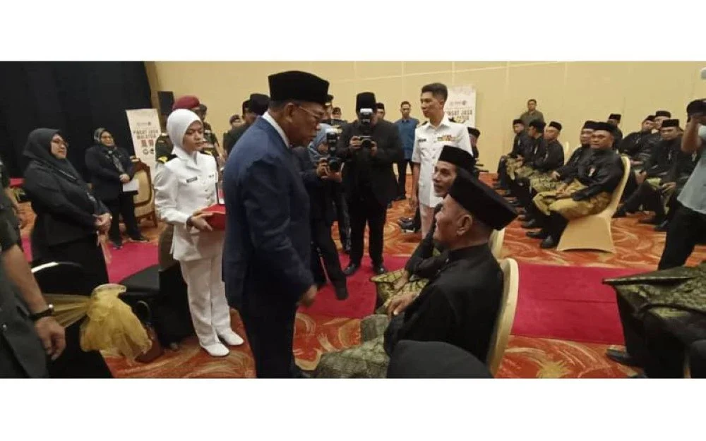 Menteri Pertahanan, Datuk Seri Mohamed Khaled Nordin (tengah) menyantuni veteran ATM kurang upaya pada majlis penganugerahan Pingat Jasa Malaysia (PJM).