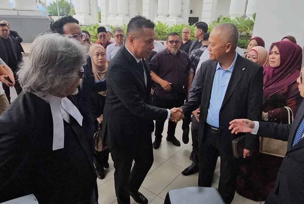 Andi Muhammad Suryady (dua dari kiri) ketika tiba di Mahkamah Khas Rasuah, Kota Kinabalu pada Isnin