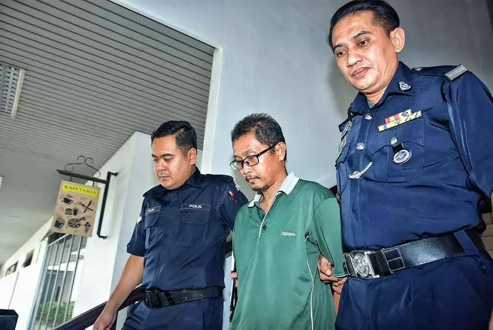 Mahfuz (tengah) ketika dibawa keluar dari Mahkamah Sesyen pada Isnin.