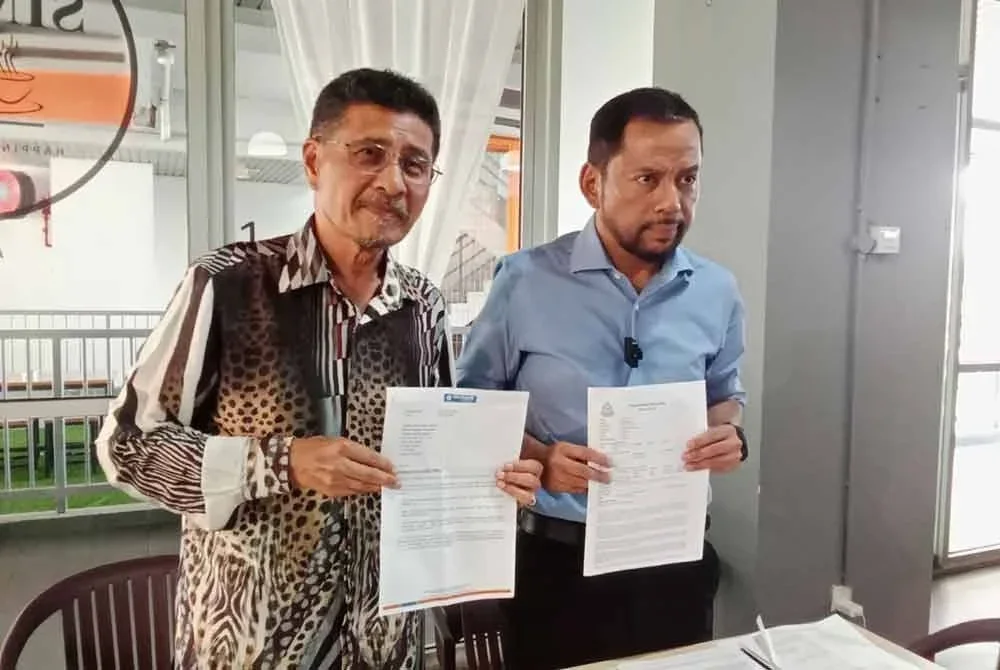 Syaiful Rizal (kanan) dan Abdullah Sani menunjukkan laporan polis dan surat berkaitan ketika sidang akhbar pada Isnin.