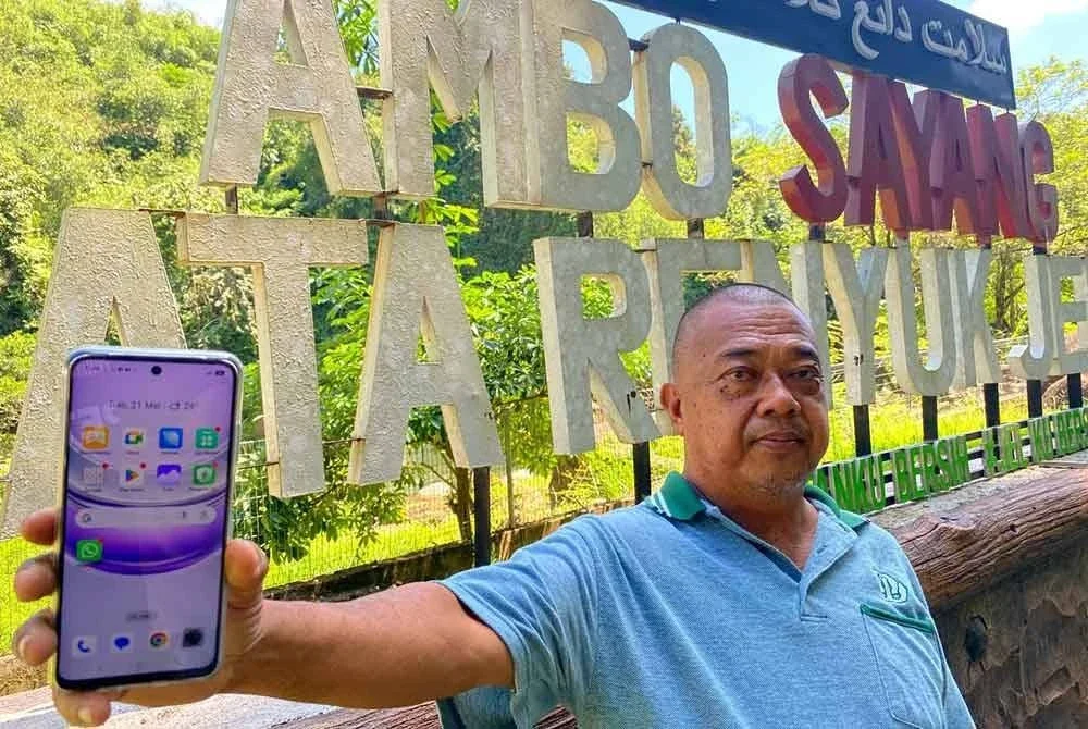 Abu Bakar menunjukkan telefonnya yang tidak mempunyai rangkaian talian semasa berada di Lata Renyuk, Jeli.