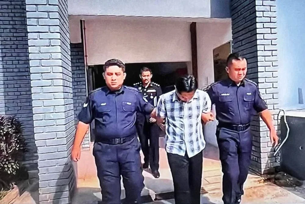 Tertuduh (tengah) ketika dihadapkan ke Mahkamah Sesyen Temerloh pada Isnin.