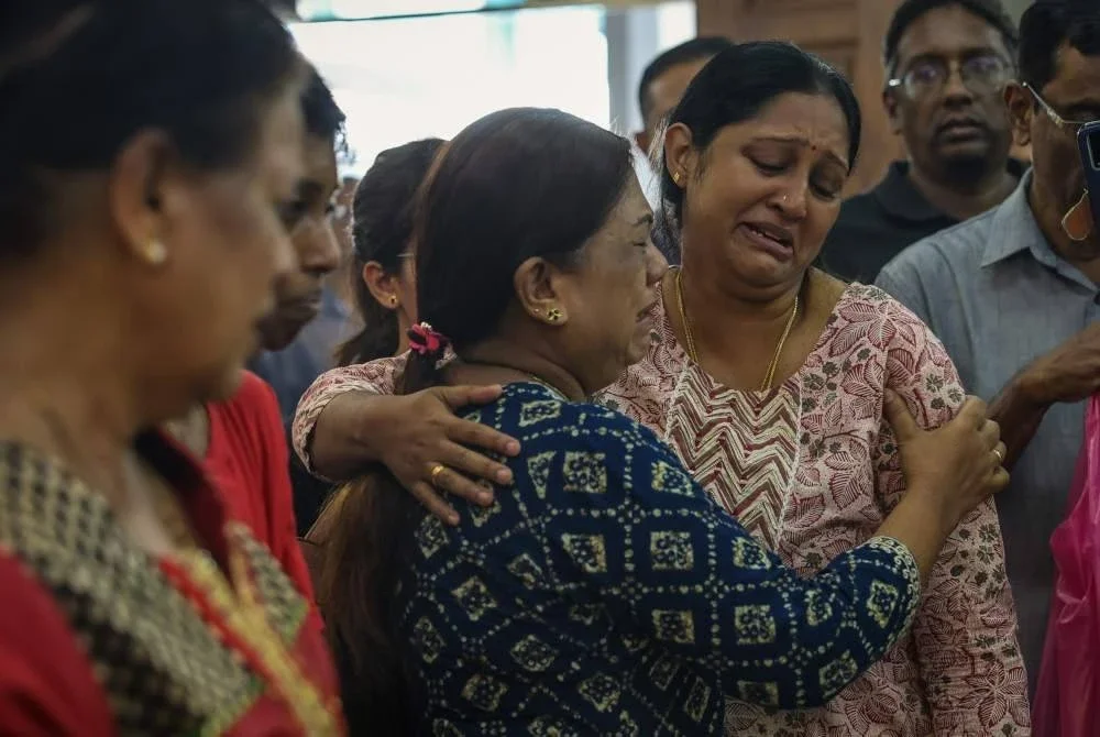 Sanggetha sebak ketika memberi penghormatan terakhir terhadap mendiang suami dan anaknya di kediaman mereka dekat Taman Bayu Aman pada Isnin. Foto Bernama