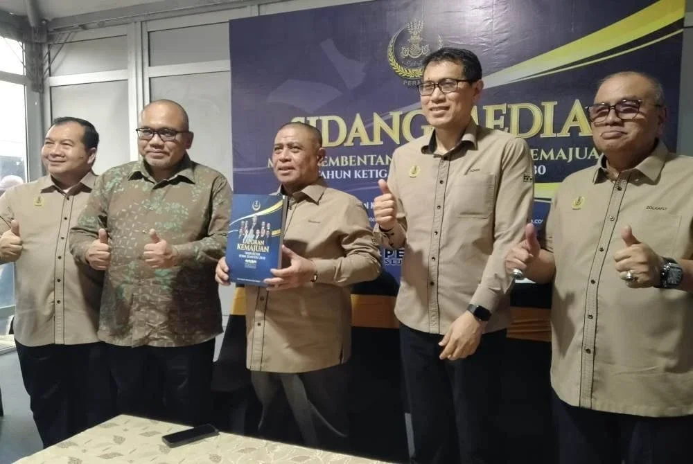 Saarani (tengah) menunjukkan Buku Laporan Kemajuan Tahun Ketiga Pelan Perak Sejahtera 2030 selepas membentangkannya di Kolej Kemahiran Tinggi Mara di sini pada Isnin.