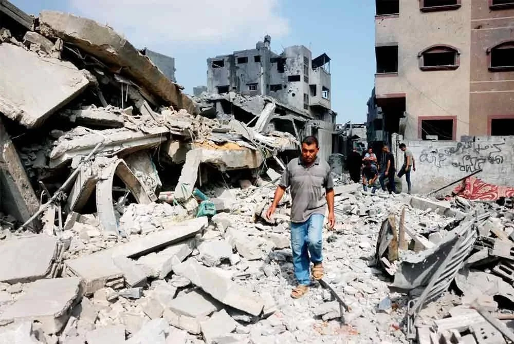 Seorang lelaki Palestin berjalan di sebelah runtuhan sebuah rumah kediaman yang musnah akibat serangan udara Israel pada waktu malam di Jabalia, utara Semenanjung Gaza, pada 30 Jun 2025. Foto AFP