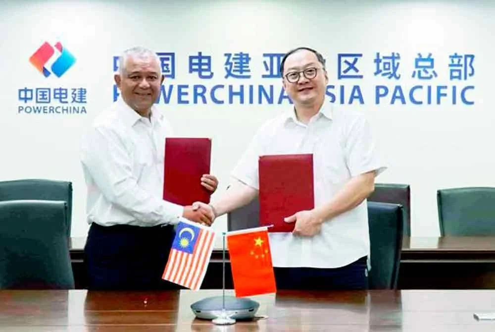 Ketua Pegawai Eksekutif Kumpulan DNeX, Faizal Sham Abu Mansor (kiri) bertukar dokumen perjanjian dengan Pengarah Urusan Sinohydro Corporation (M) Sdn Bhd, Zhou Jiayi (kanan).