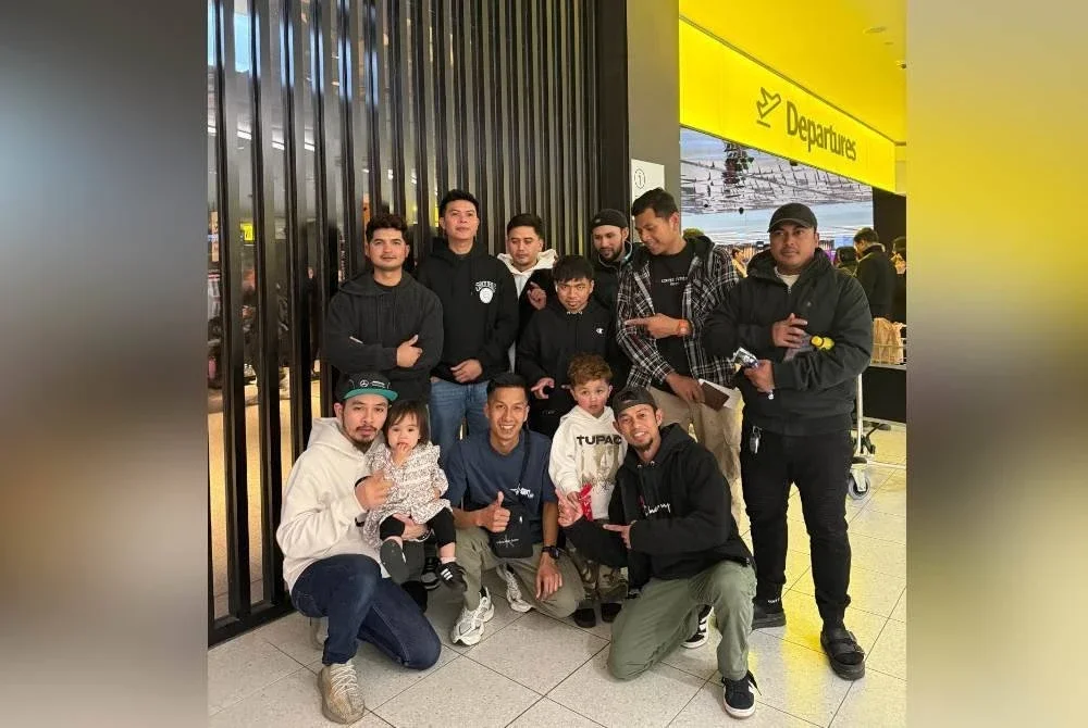 Mohamad Hilmi (tengah) bersama kedua ibu bapanya dan ahli keluarga merakan kenangan ketika kepulangannya.