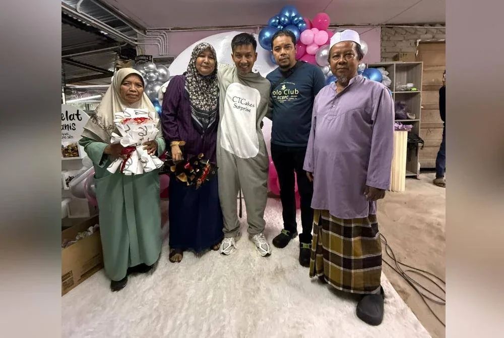 Mohamad Hilmi (tengah) bersama kedua ibu bapanya dan ahli keluarga merakan kenangan ketika kepulangannya.