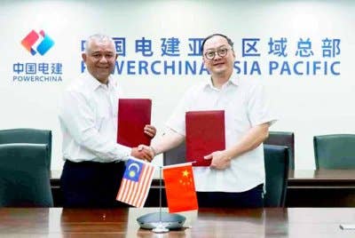 Ketua Pegawai Eksekutif Kumpulan DNeX, Faizal Sham Abu Mansor (kiri) bertukar dokumen perjanjian dengan Pengarah Urusan Sinohydro Corporation (M) Sdn Bhd, Zhou Jiayi (kanan).