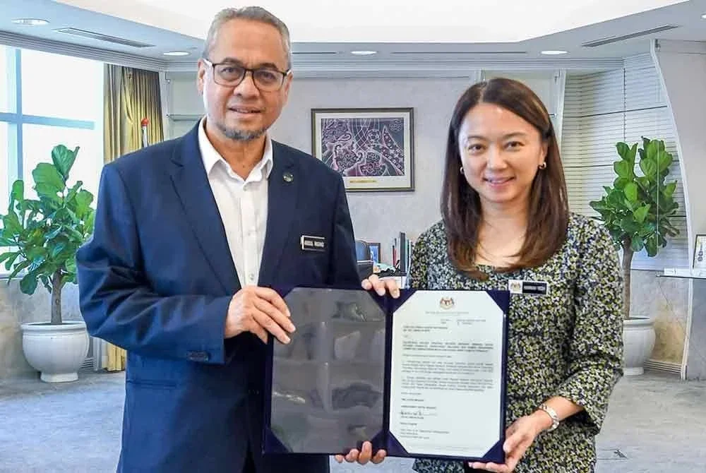Hannah (kanan) menyerahkan surat pelantikan sebagai CEO Sukan SEA 2027 kepada Abdul Rashid. Foto KBS.