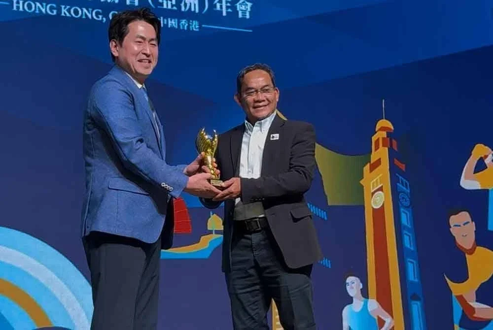 Abu Bakar (kanan) menerima anugerah Legend of AIPS Asia daripada Presiden AIPS Asia, Hee Don Jung di Hong Kong pada Selasa.