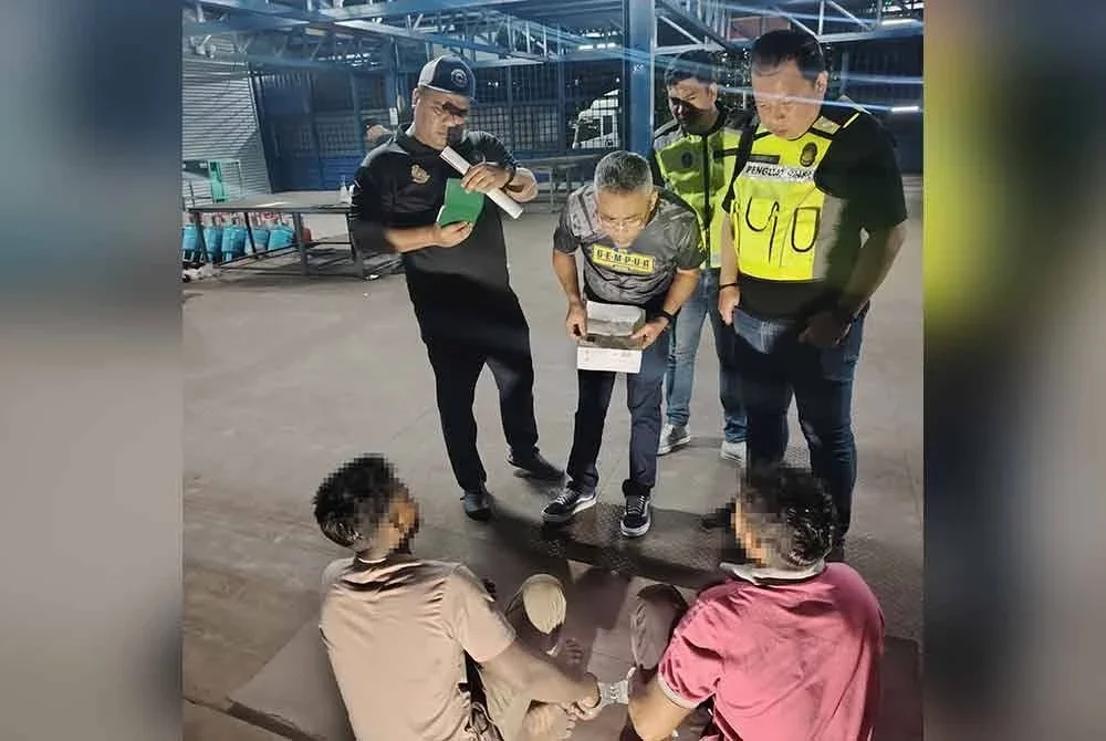 Mohd Sabri (dua dari kanan) menyoal siasat dua pekerja warga asing yang ditahan semasa serbuan gudang di Jalan Ipoh, Kuala Lumpur.