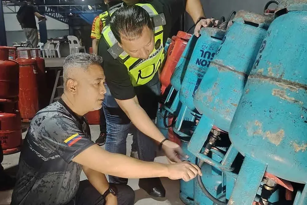 Mohd Sabri (kiri) meninjau dalam gudang di Jalan Ipoh, Kuala Lumpur yang dipercayai melakukan kerja penyelewengan barang kawalan bersubsidi melibatkan LPG.