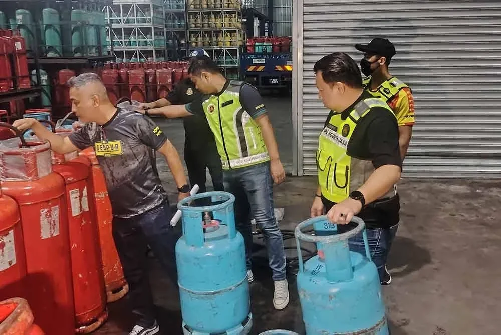 Mohd Sabri (kiri) meninjau dalam gudang di Jalan Ipoh, Kuala Lumpur yang dipercayai melakukan kerja penyelewengan barang kawalan bersubsidi melibatkan LPG.