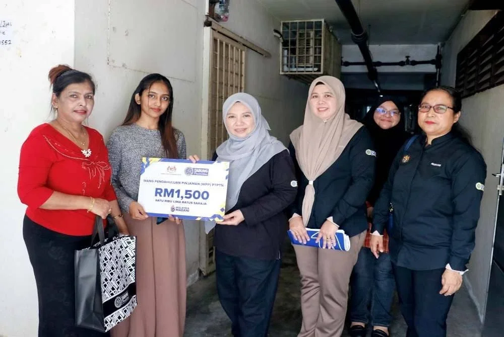 Norliza (tiga dari kiri) menyerahkan surat tawaran WPP kepada salah seorang penerima di Bukit Gelugor, Pulau Pinang.