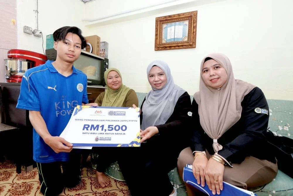 Norliza (dua dari kanan) menyerahkan surat tawaran WPP kepada salah seorang pelajar yang layak di Pulau Pinang. 