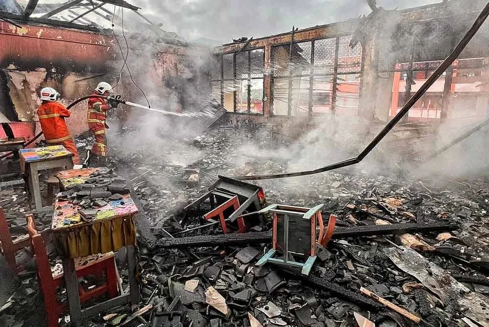 Pasukan bomba sedang memadamkan kebakaran di Sekolah Menengah Kebangsaan (SMK) Dang Anum, Merlimau di sini, pada awal pagi Khamis