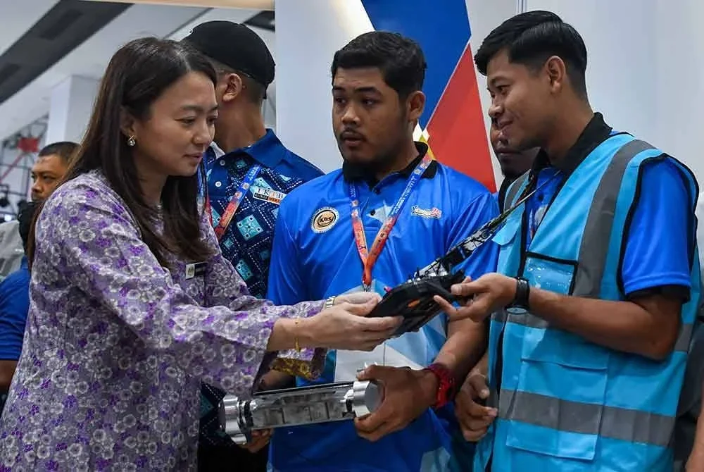 Menteri Belia dan Sukan, Hannah Yeoh (kiri) melihat alat kawalan jauh yang digunakan pasukan Malaysia 1 daripada Institut Kemahiran Tinggi Belia Negara (IKTBN), Bachok pada Majlis Perasmian Cabaran Robotik Belia Asean 2025 (ASEAN Y-RoboC'25) di Mydin Mall Tunjung pada Khamis. Foto Bernama