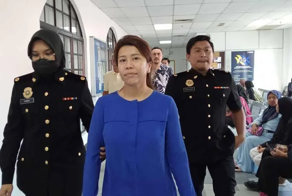 Tertuduh, Sahela Abdul Rahim (tengah) ketika dibawa ke Mahkamah Sesyen Johor Bahru pada Jumaat.