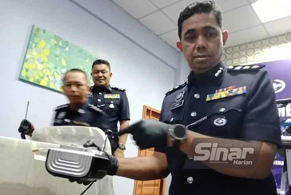 Muhamad Farid menunjukkan mesin pembuat rokok yang dirampas dalam serbuan pada Selasa.