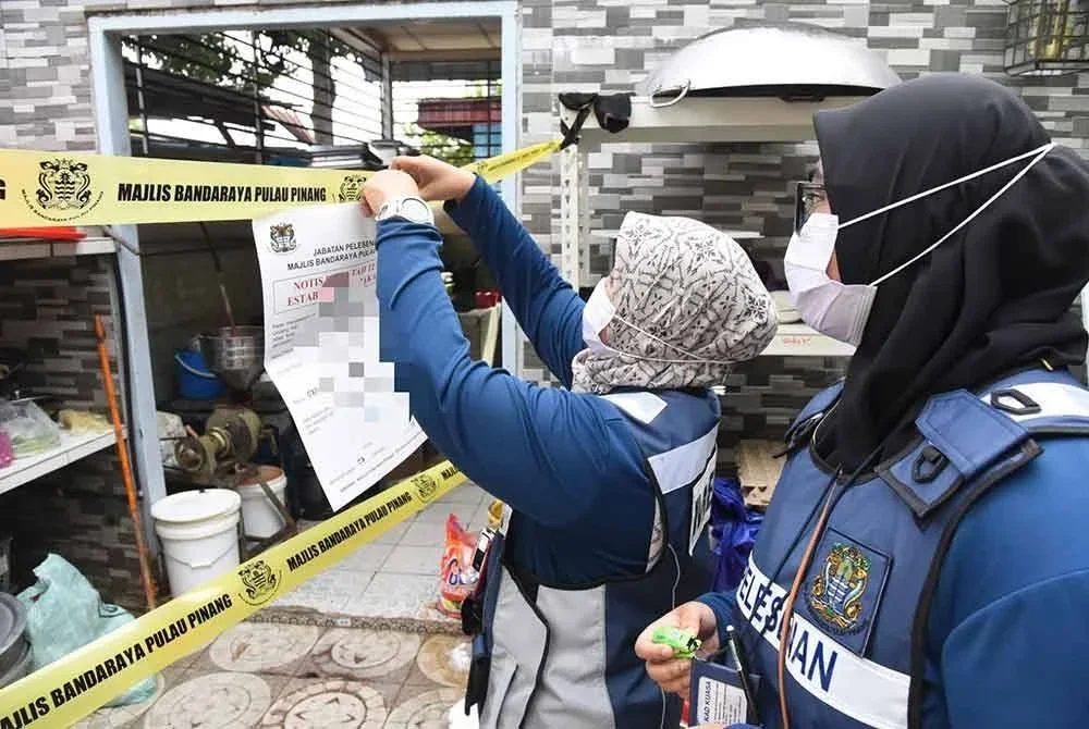 Pegawai MBPP melekatkan notis penutupan pada salah sebuah premis yang diperiksa pada Khamis. Foto FB MBPP