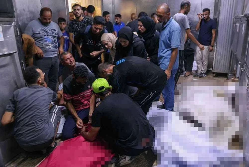 Warga Palestin dilihat menangisi jenazah ahli keluarga mereka yang terkorban dalam serangan udara Israel ke atas kafeteria Al-Baqa yang terletak di tepi pantai Gaza, di Hospital Al-Shifa. Foto AFP