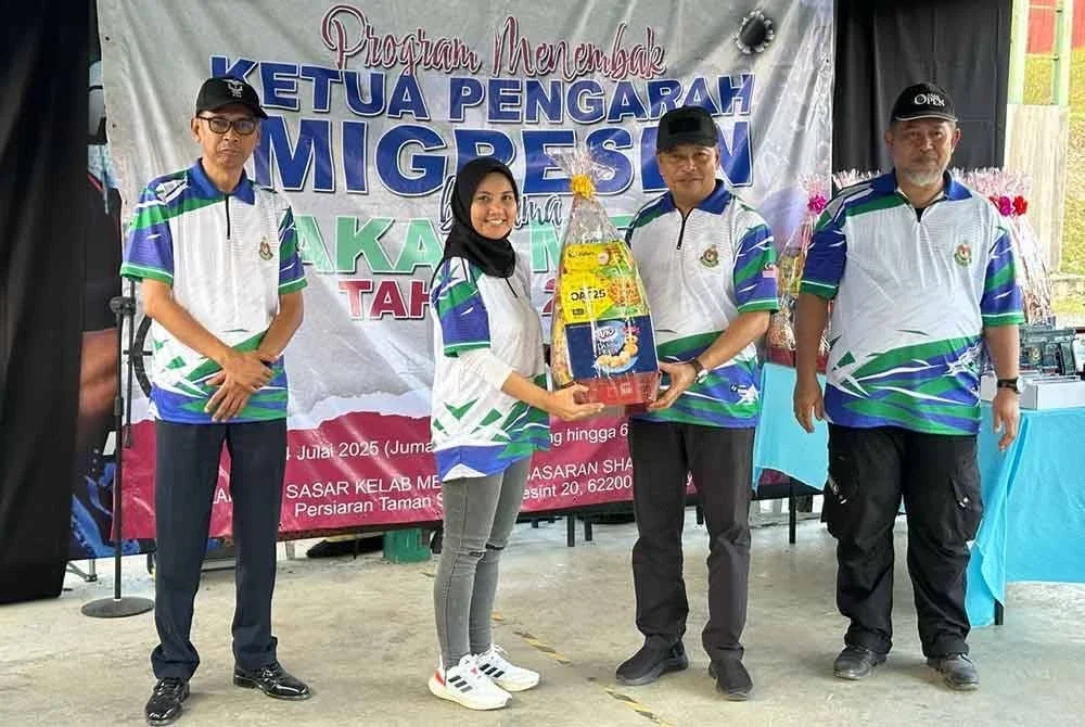 Zakaria (dua dari kanan) menyampaikan cenderamata kepada wartawan yang menyertai program menembak JIM bersama petugas media di Putrajaya pada Jumaat.