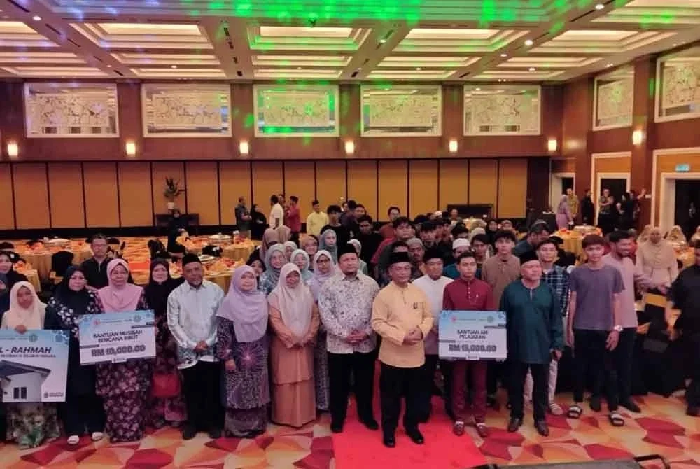 Mohd Na'im (tujuh dari kiri) bersama tetamu dan penerima sumbangan bergambar sempena Majlis Rai Ummah YB Menteri Bersama Komuniti Di Kota Bharu pada Jumaat.
