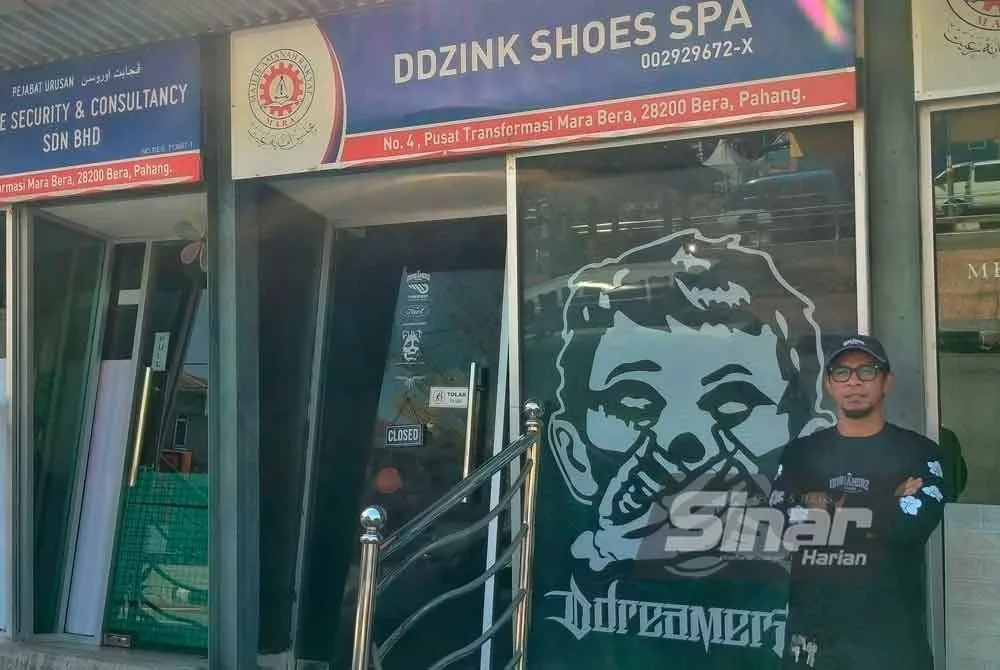 Redzuan di hadapan bengkel dan spa kasut yang terletak di bandar Bera.