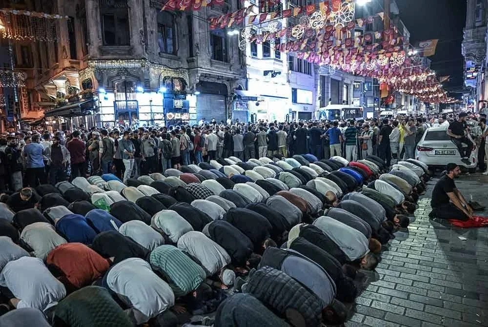 Penunjuk perasaan menunaikan solat ketika berhimpun berhampiran pejabat majalah LeMan di Istanbul. Foto Agensi/ AFP