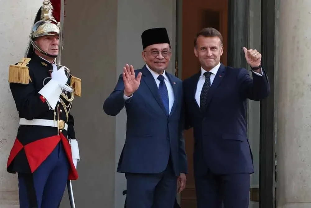 Anwar (tengah) bersama Macron di Istana Elysee. Foto Bernama