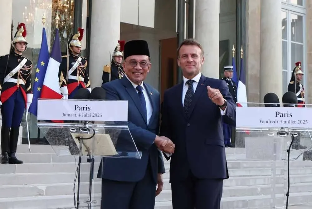 Anwar (depan, kiri) bersalaman bersama Macron selepas sidang media di Istana Elysee. Foto Bernama
