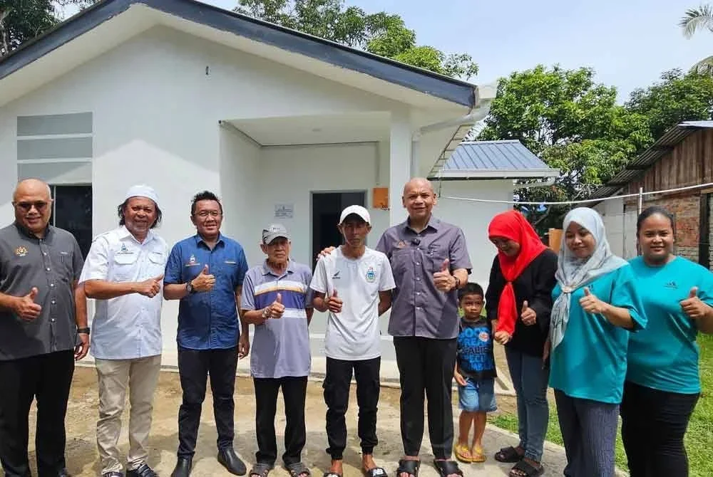 Armizan (empat dari kanan) bersama penerima Rumah Mesra SMJ, Zuraidin (lima dari kanan) di Kampung Kalanahan Rimba, Papar.