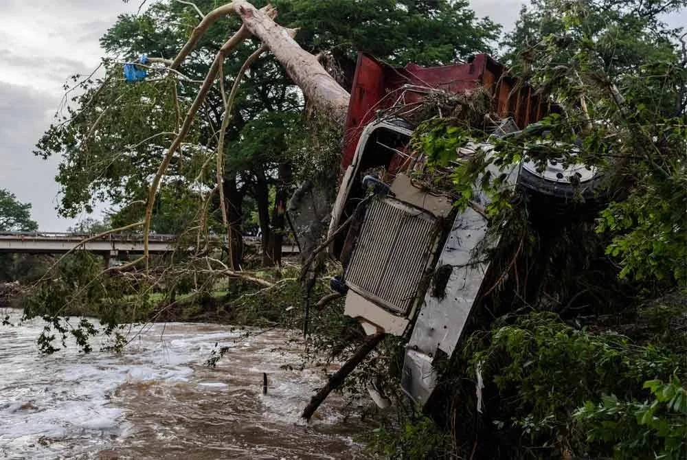 Sebuah trak besar tersekat pada pokok selepas banjir kilat di tebing Sungai Guadalupe. Foto AFP