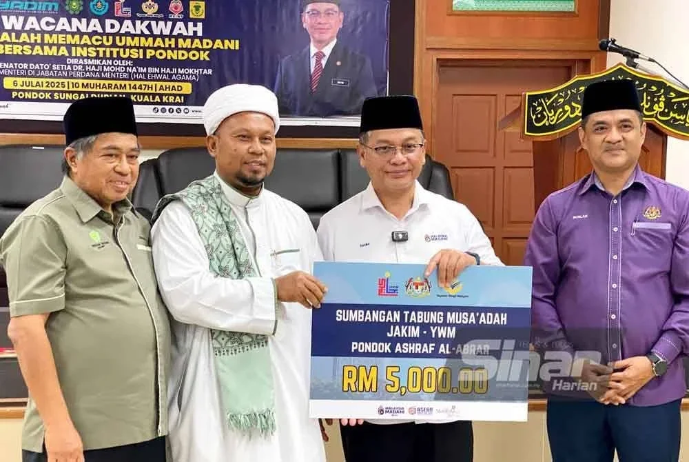Mohd Na'im (dua dari kanan) menyampaikan sumbangan kepada wakil pondok pada Wacana Dakwah Al-Falah Memacu Ummah Madani Bersama Institusi Pondok di Pondok Sungai Durian, Kuala Krai pada Ahad.