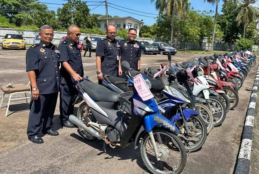 Mohd Misuari (dua dari kanan) bersama pegawainya melihat motosikal yang berjaya dilelong.