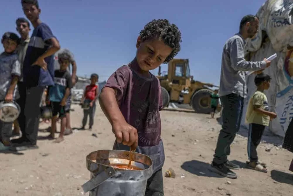 Seorang budak lelaki membantu datuknya memasak spageti di Khan Younis, utara Rafa. Foto: WFP