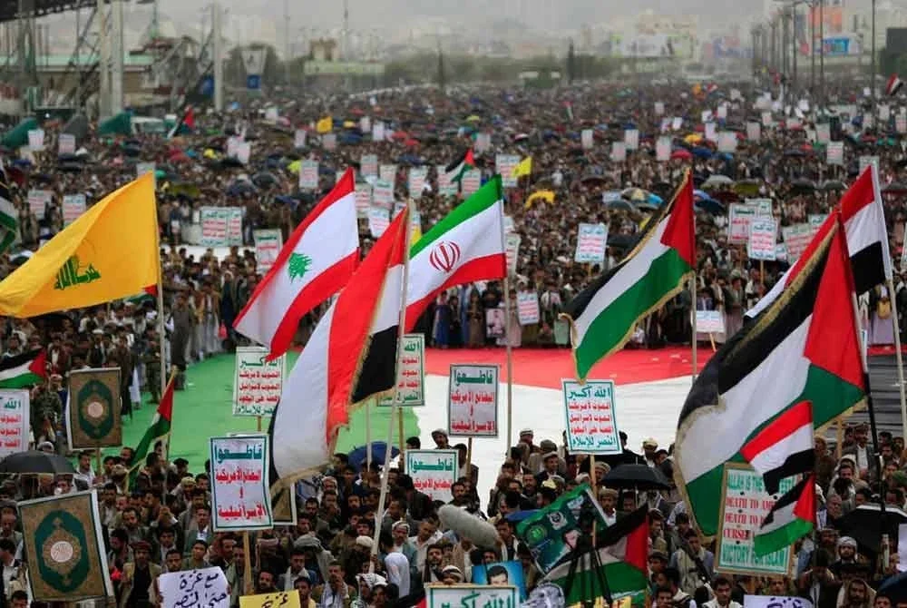 Penyokong mengibarkan bendera Hizbullah, Lebanon, Iran dan Palestin pada himpunan solidariti Genting Gaza. - AFP
