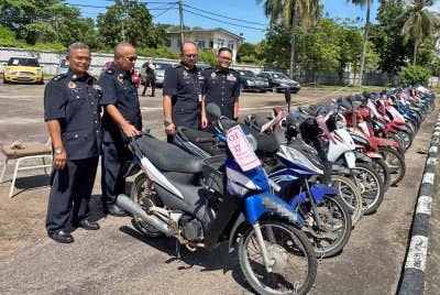 Mohd Misuari (dua dari kanan) bersama pegawainya melihat motosikal yang berjaya dilelong.