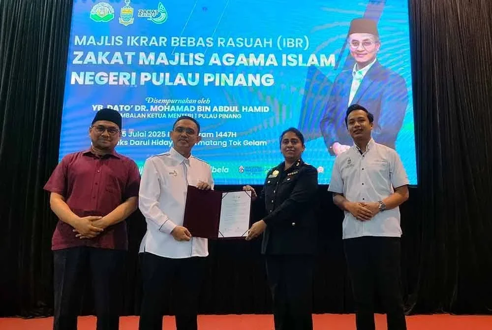 Mohamad Khairi (dua dari kiri) menyerahkan dokumen ikrar bebas rasuah kepada wakil SPRM.