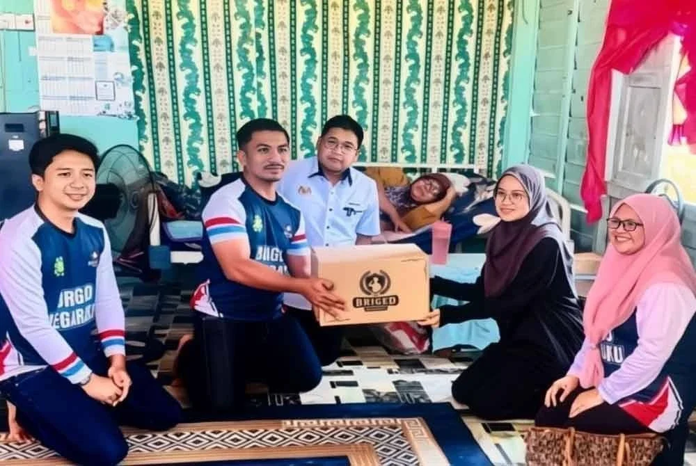 Che Nur Anis (dua, kanan) semasa menerima kunjungan daripada Briged Negaraku Kelantan wakili oleh Muhammad Arief (dua, kiri) di rumahnya di Jalan Embung, Kuala Krai.