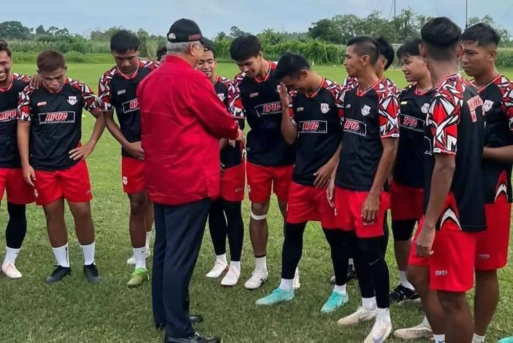 Annuar bersalaman dengan pemain Kelantan Wan Tendong Stable yang beraksi di Liga A1 di Tendong, Pasir Mas.