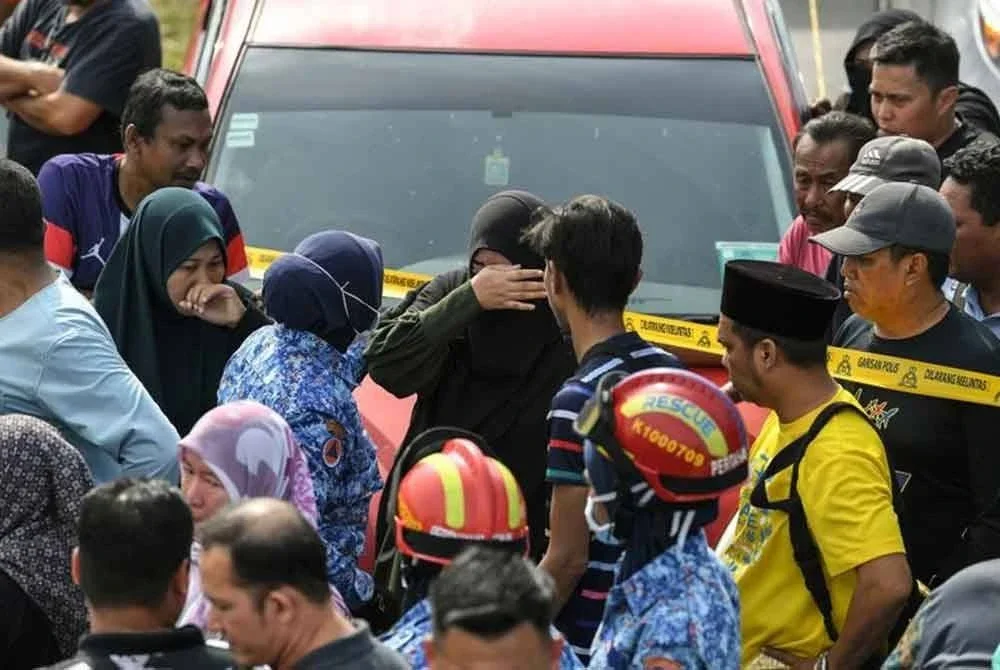 Sebahagian ahli keluarga dan kenalan tidak dapat menahan kesedihan selepas melihat enam mayat yang ditemukan dalam sebuah kereta di dalam Sungai Korok, dekat Jitra pada Isnin. Foto Bernama