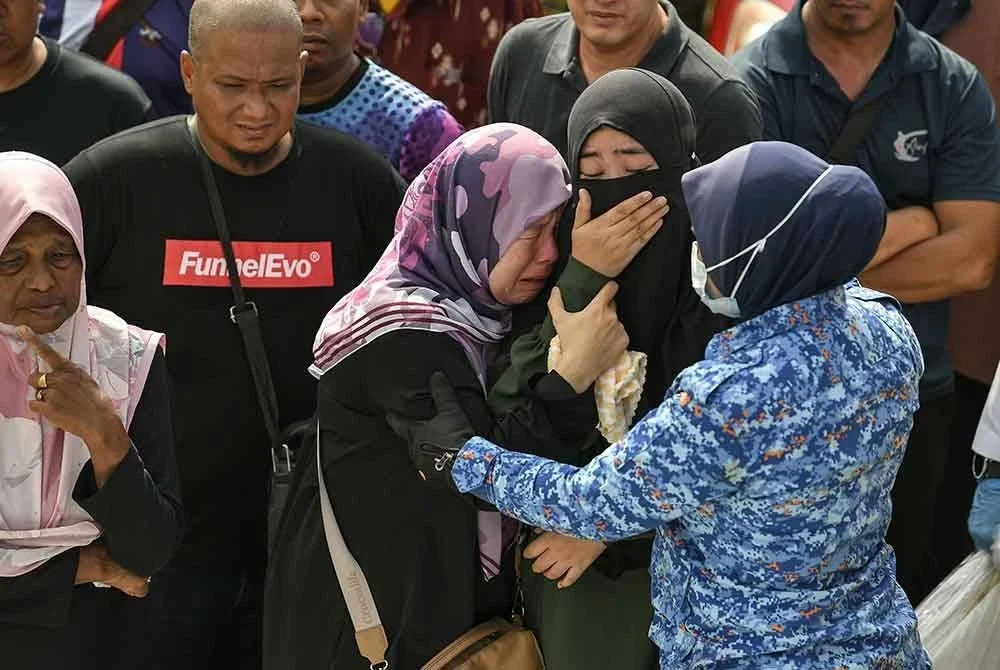 Sebahagian ahli keluarga dan kenalan tidak dapat menahan kesedihan selepas melihat enam mayat yang ditemukan dalam sebuah kereta di dalam Sungai Korok, dekat Jitra pada Isnin. Foto Bernama