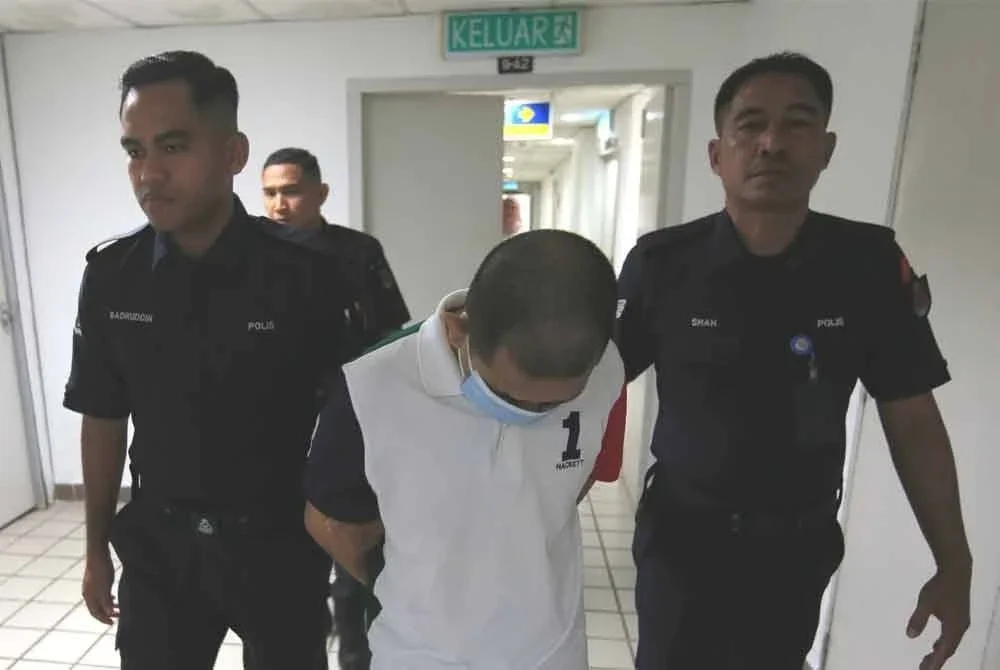 Tertuduh (tengah) dihadapkan di Mahkamah Tinggi di Kuala Terengganu pada Rabu.