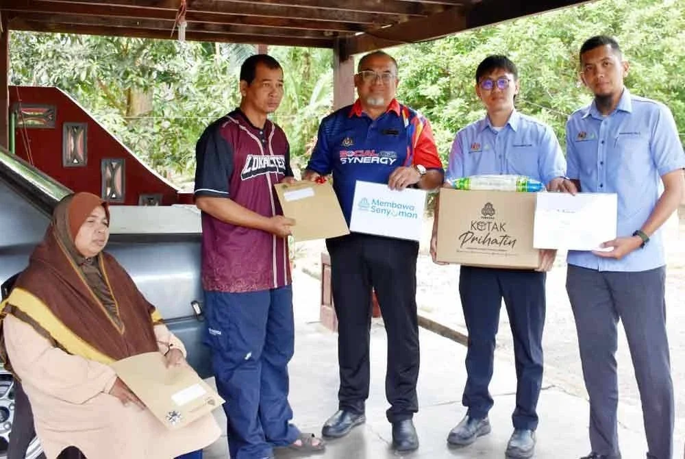 Aziz Jaafar (dua dari kiri) mewakili keluarga menerima Faedah Pengurusan Mayat (FPM) sebanyak RM3,000 sebagai bantuan urusan pengebumian. - Foto: PERKESO
